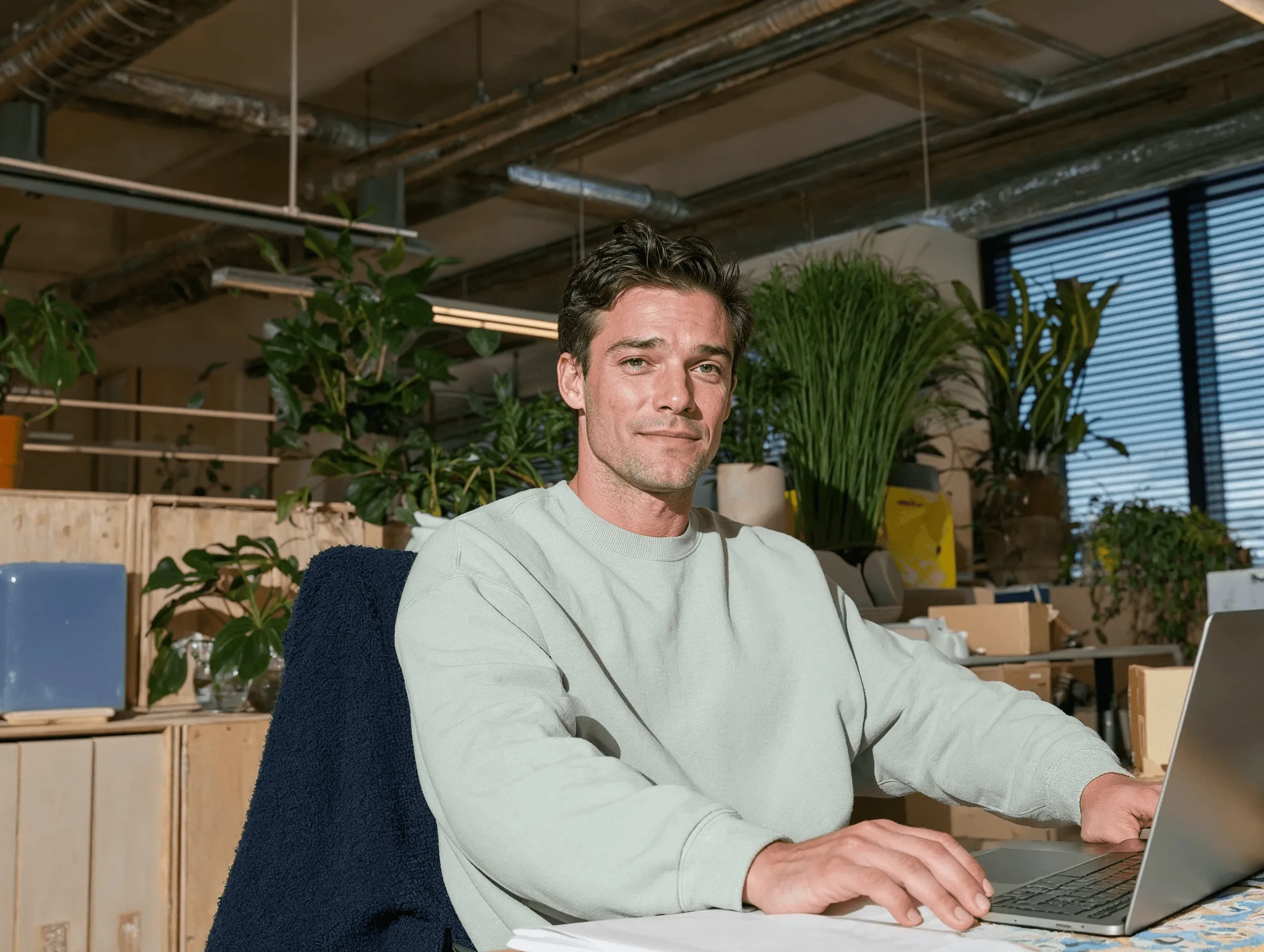 Ein Vertriebsmitarbeiter lächelt an seinem Schreibtisch in einem hellen Büro